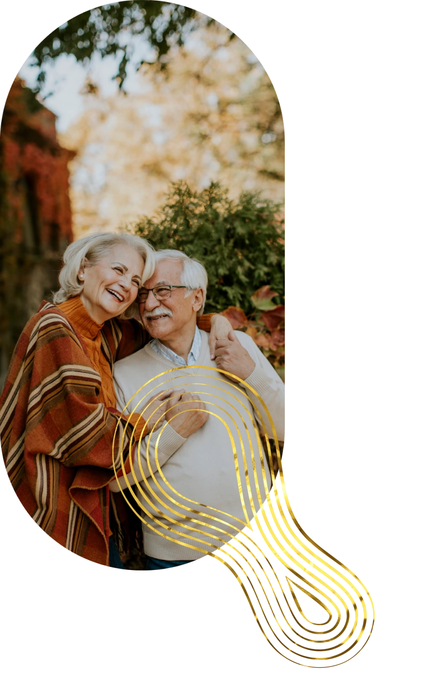 A smiling senior couple embracing outdoors